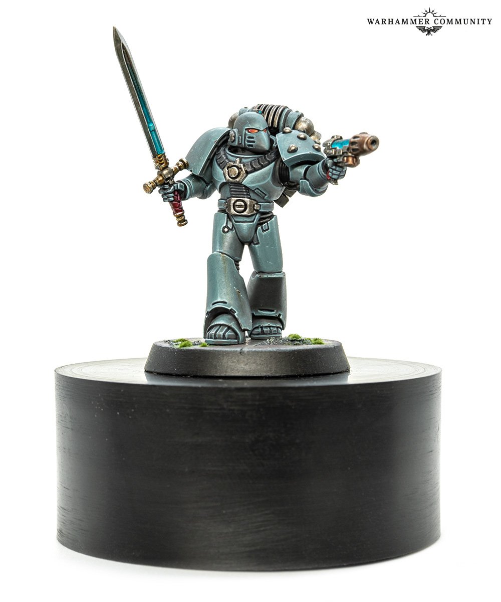 A painted Knight-Errant conversion in grey power armour, carrying a sword and bolt pistol