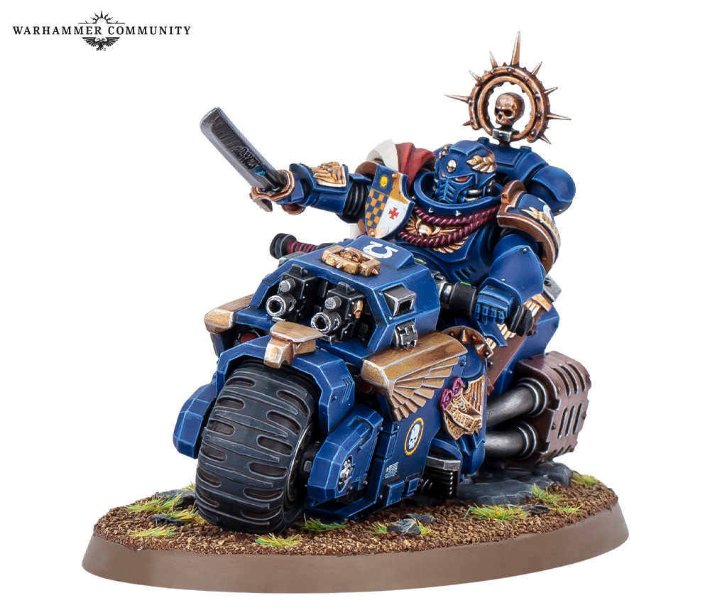 The new plastic Space Marine Captain on Bike model in Ultramarines blue, power sword raised, riding a Raider-pattern combat bike